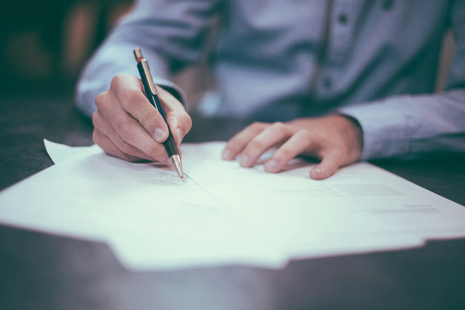 Hand with a pen filling in a document